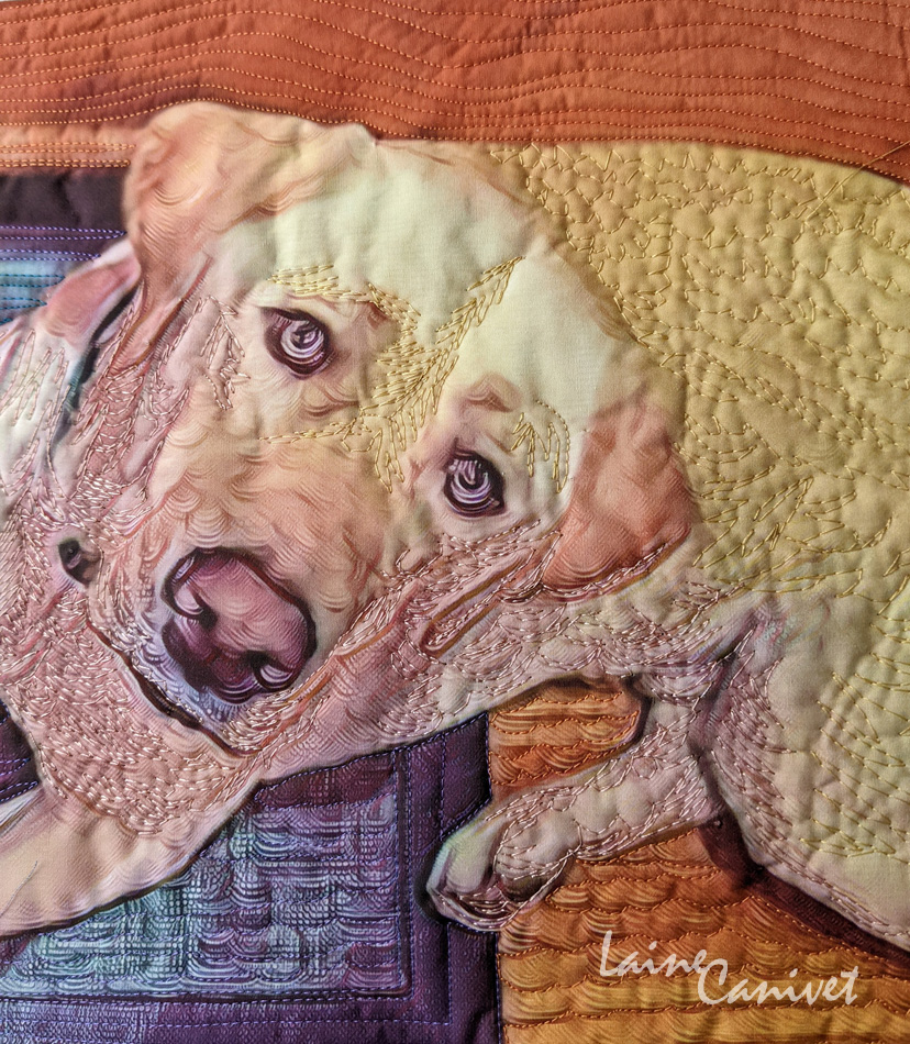 a quilt depicting a labrador retriever lying down looking up at the viewer