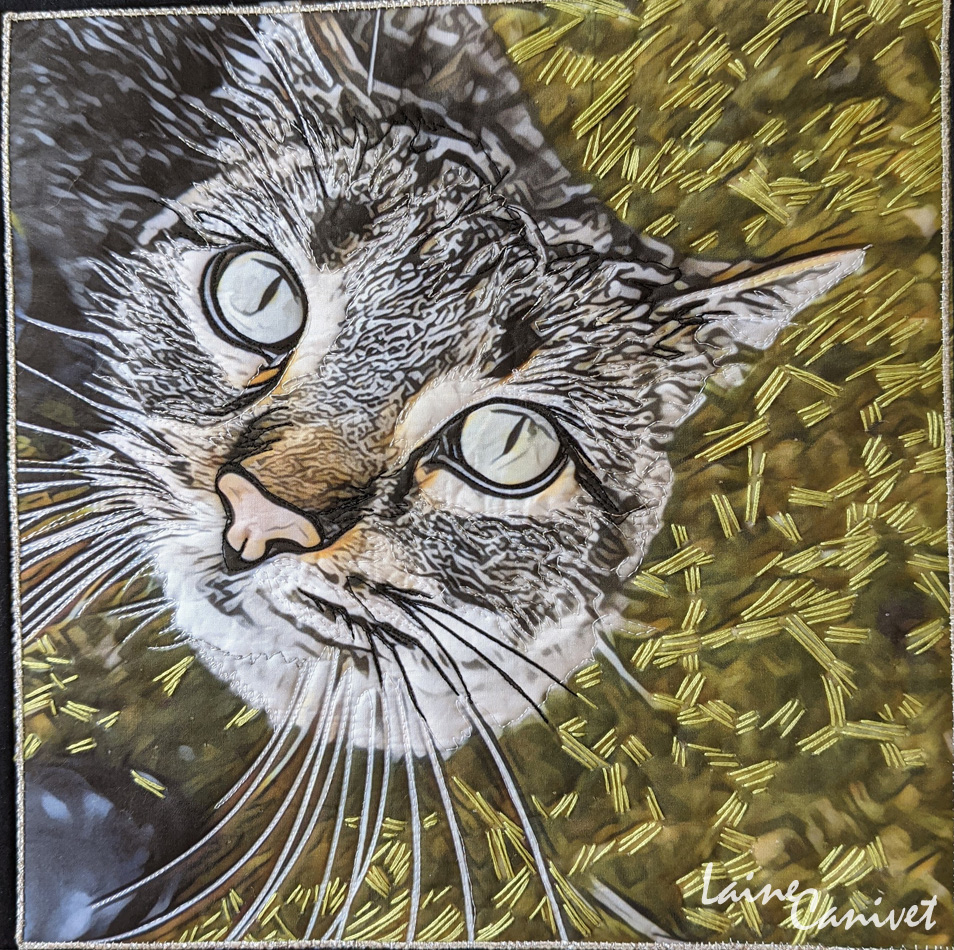 a quilt depicting the face of a grey tabby cat